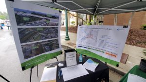 The project team's booth set up at Meeker Days. There are two boards with various project information standing behind a table. 