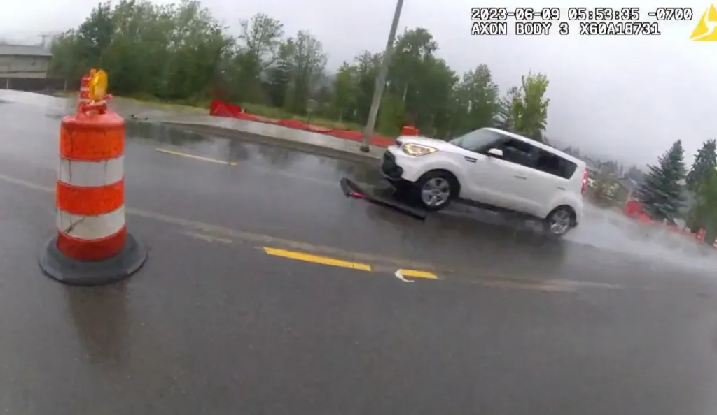 White car gets spikes thrown under its tires